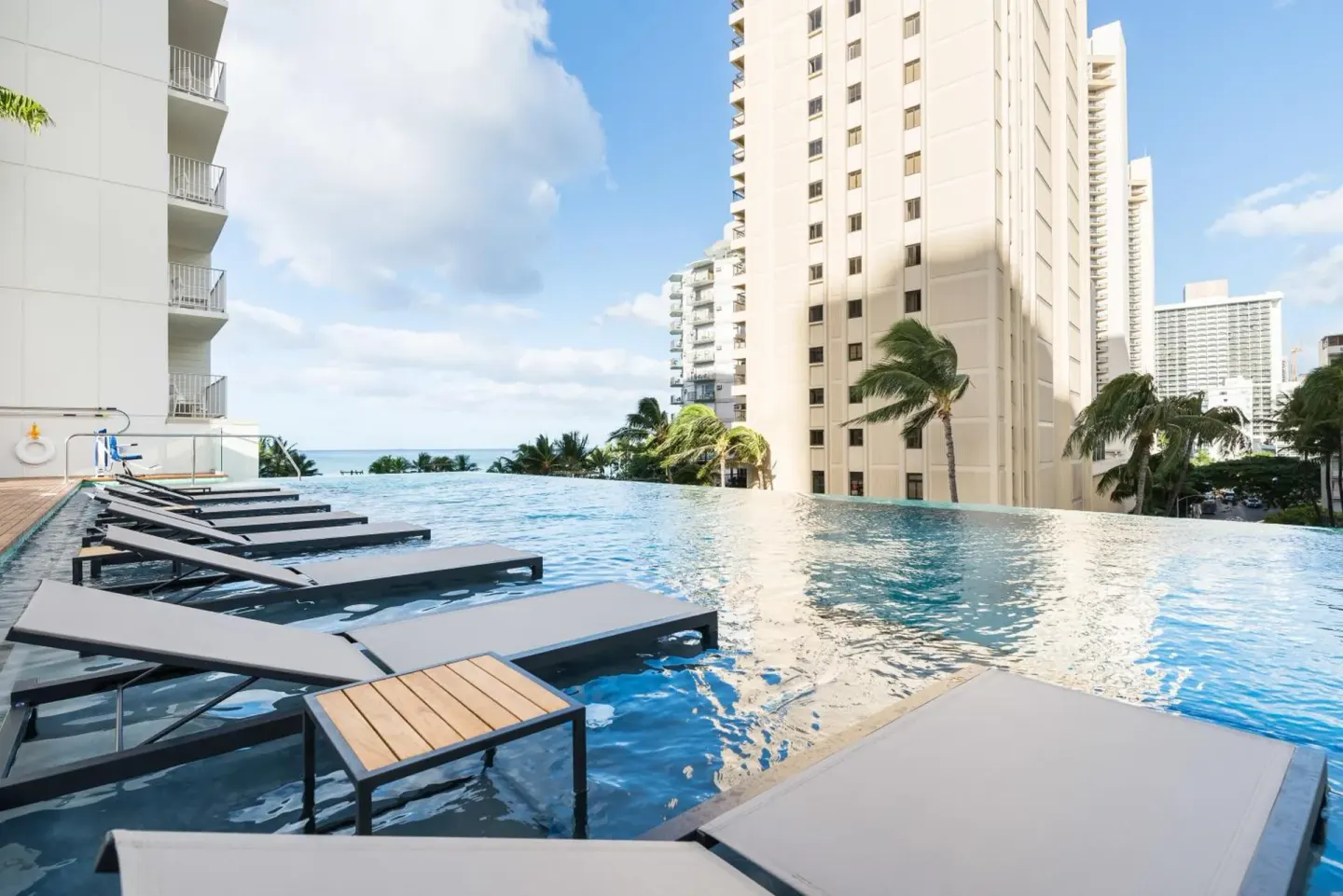 Infinity pool with in-water loungers at 'Alohilani Resort Waikiki Beach.