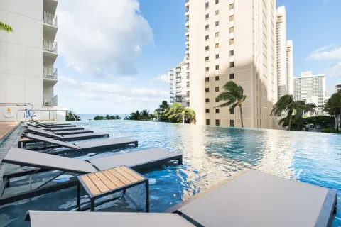 Infinity pool with in-water loungers at 'Alohilani Resort Waikiki Beach.