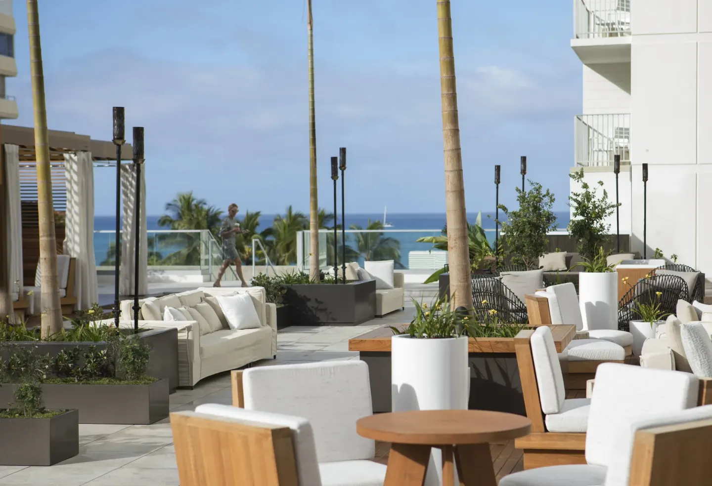 Outdoor lounge seating faces the ocean at 'Alohilani Resort Waikiki Beach.