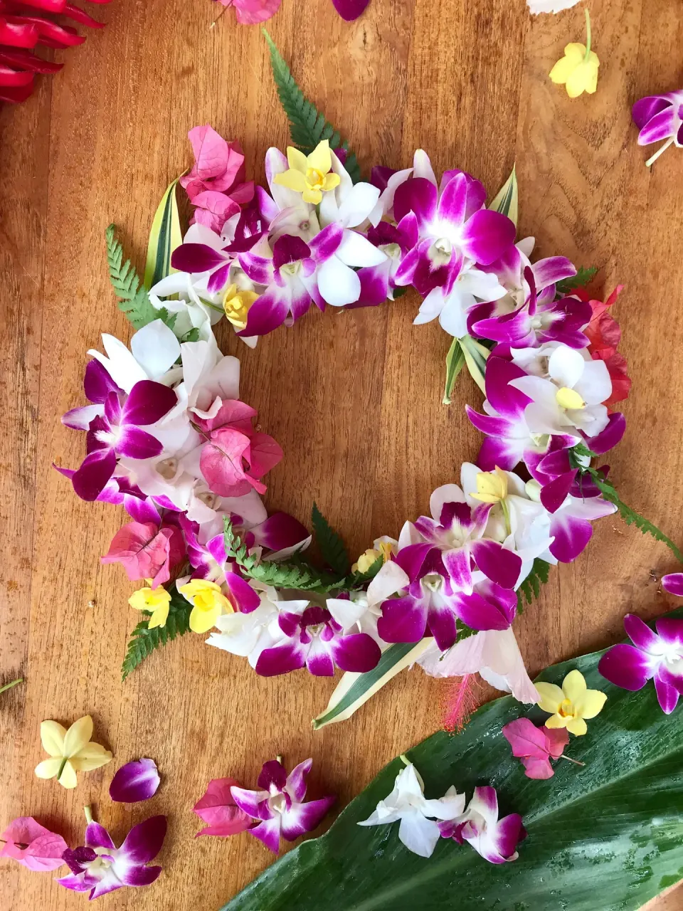 Colorful orchid lei on a wooden surface at 'Alohilani Resort Waikiki Beach.