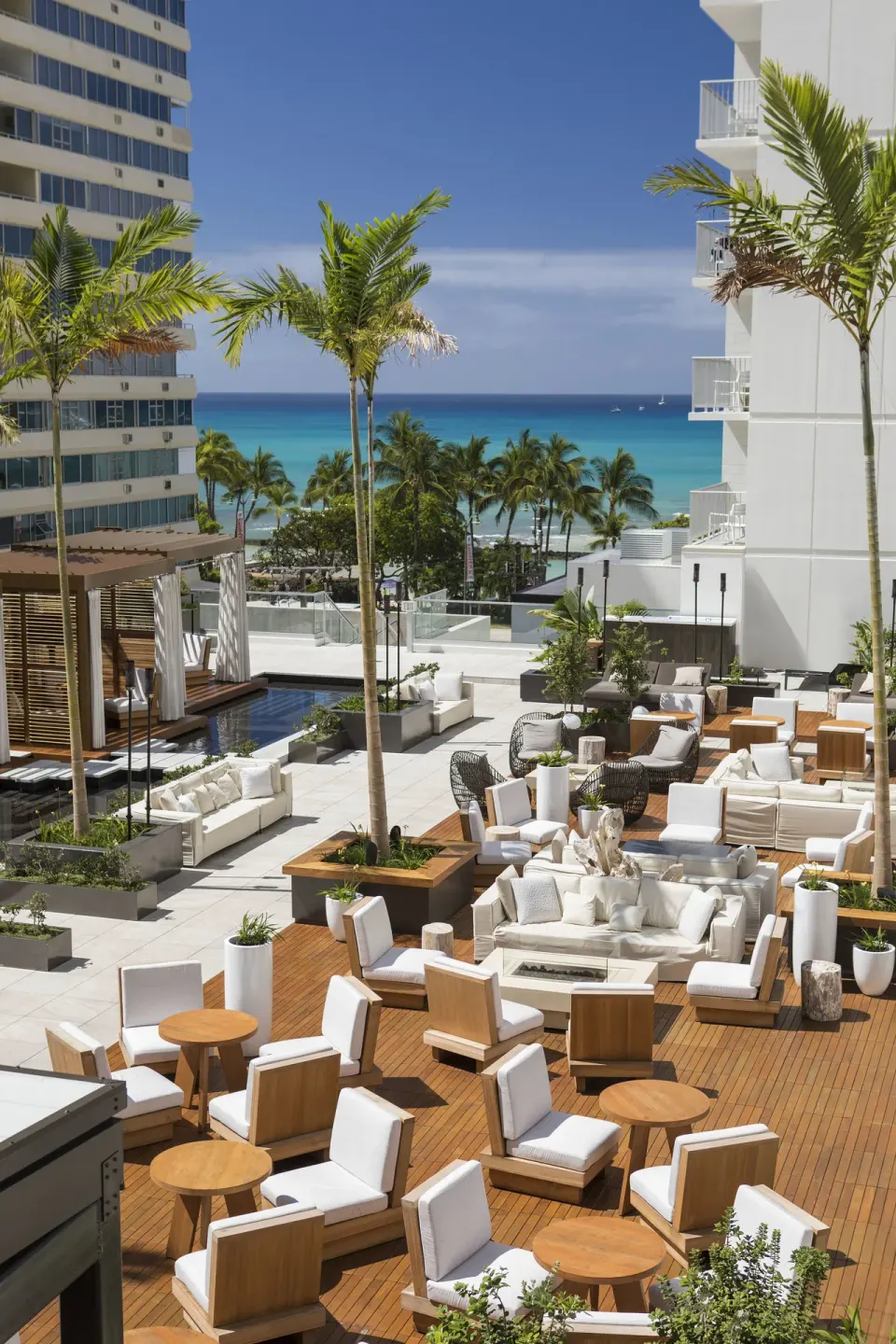 Pool terrace lounge seating with ocean backdrop at 'Alohilani Resort Waikiki Beach.