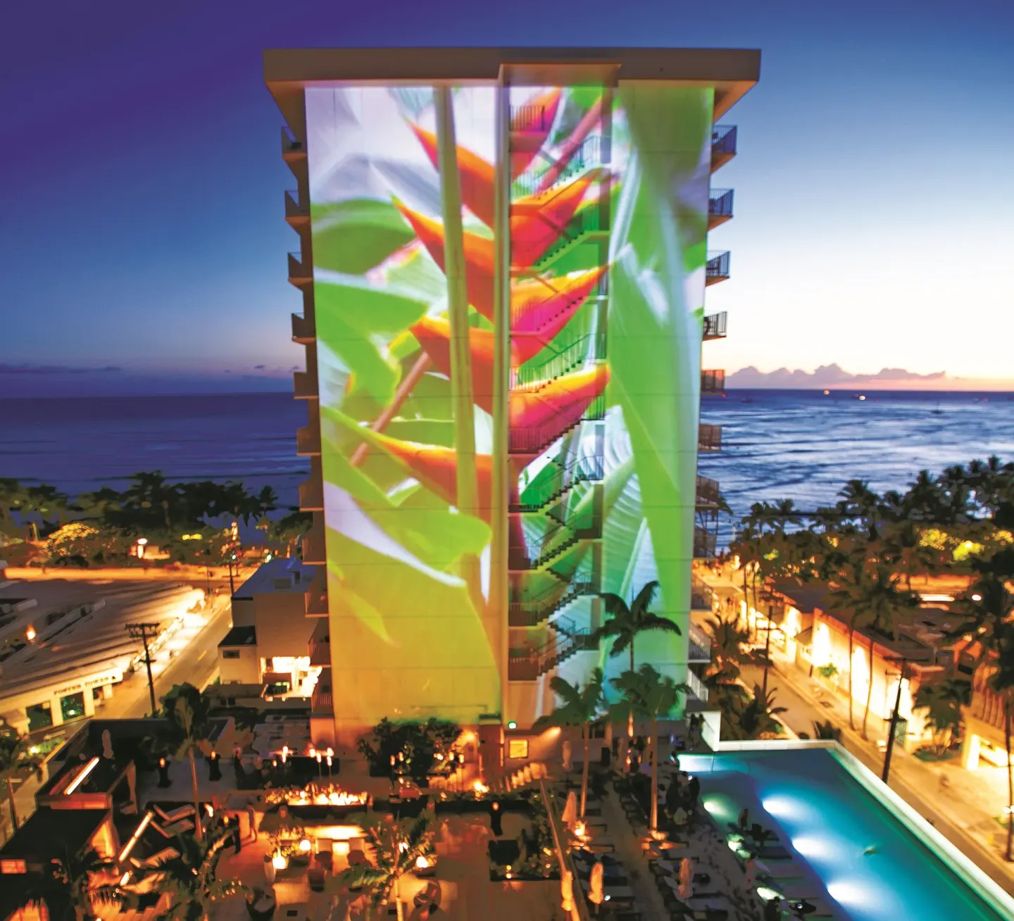 Colorful projected artwork covers a tower above the pool at 'Alohilani Resort Waikiki Beach.