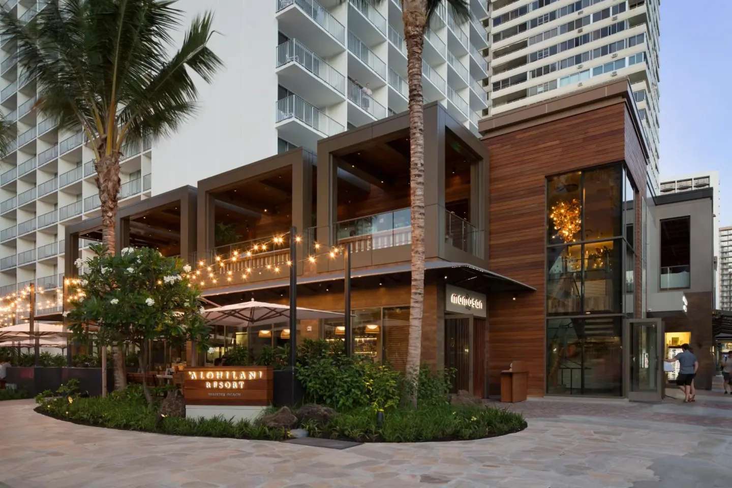 Exterior entrance with palm trees and resort signage at 'Alohilani Resort Waikiki Beach.