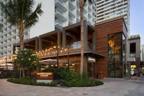 Exterior entrance with palm trees and resort signage at 'Alohilani Resort Waikiki Beach.