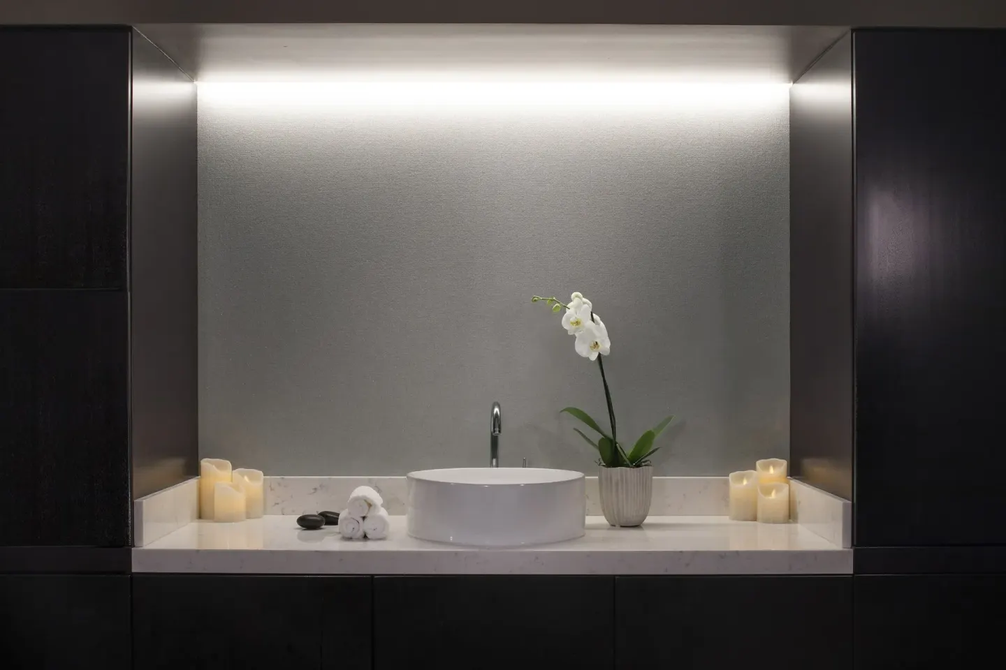 Spa treatment room sink with candles and an orchid at 'Alohilani Resort Waikiki Beach.
