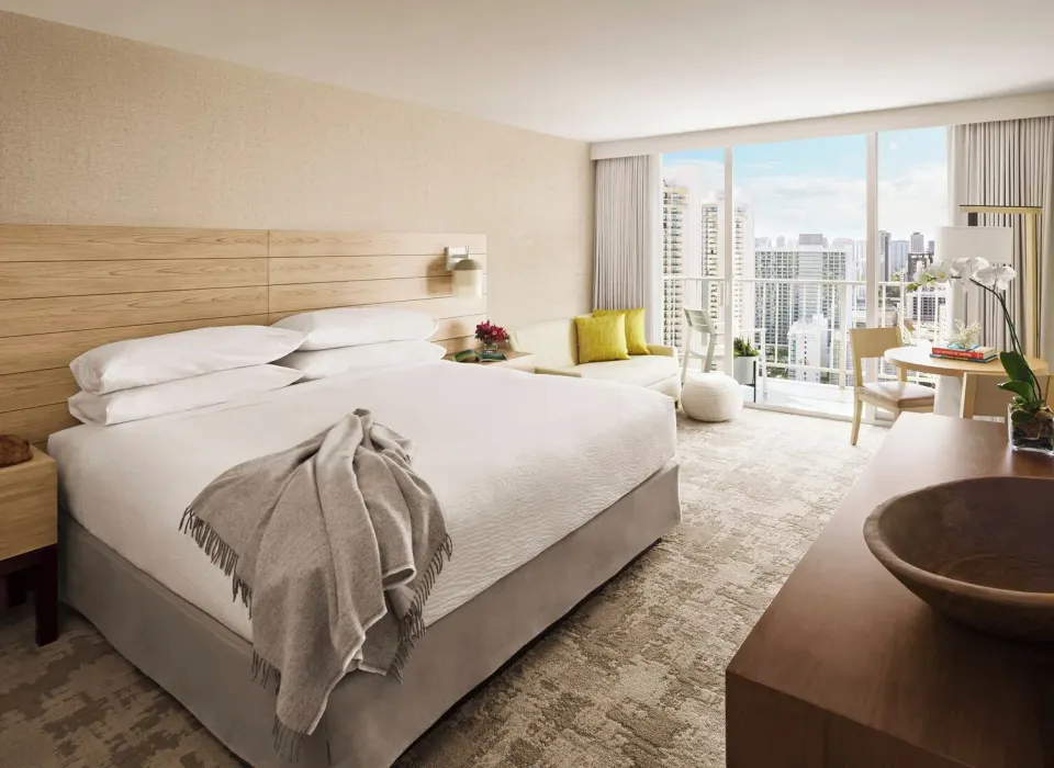Classic Room king bed with seating and city view at 'Alohilani Resort Waikiki Beach.
