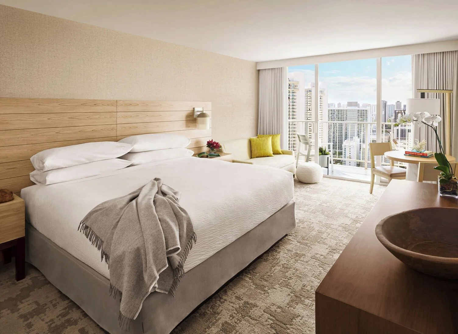 Classic Room king bed with seating and city view at 'Alohilani Resort Waikiki Beach.
