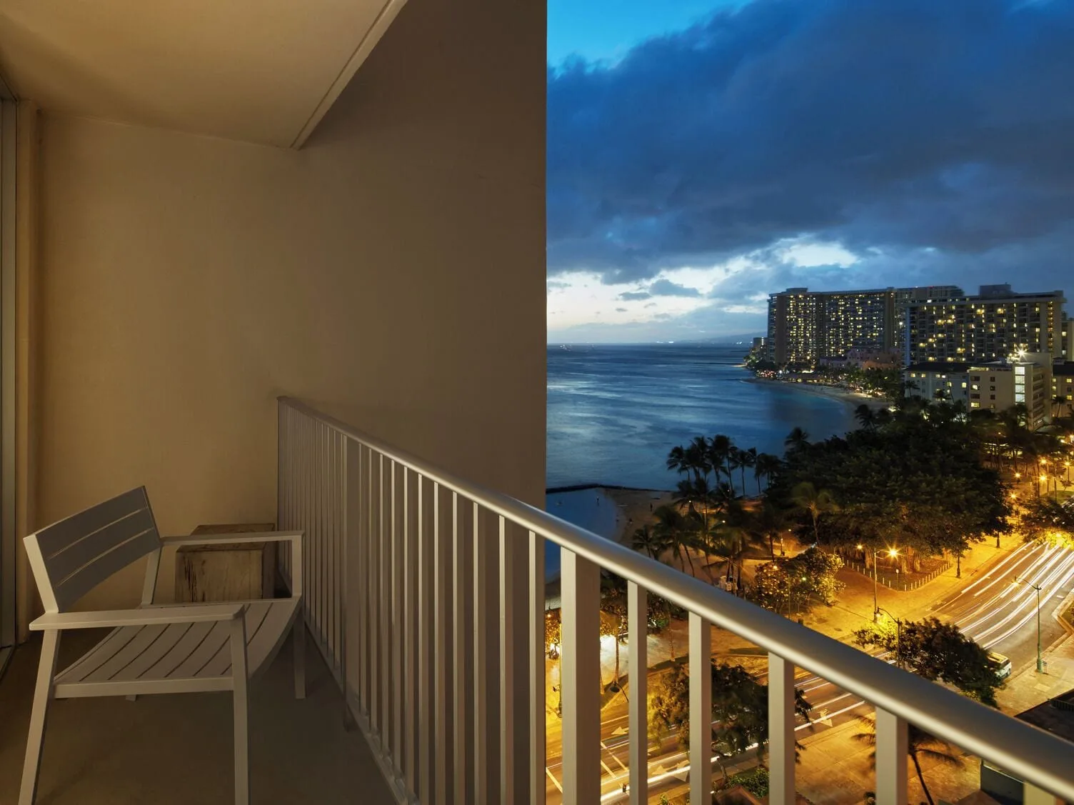 Ocean View room balcony overlooking Waikiki at dusk at 'Alohilani Resort Waikiki Beach.