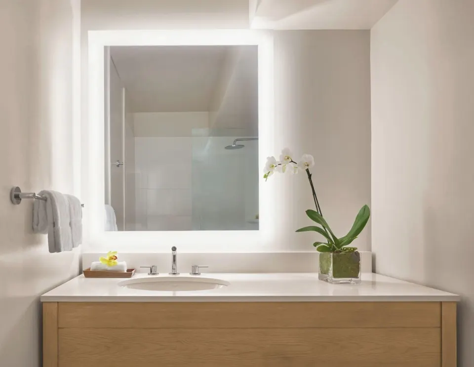 Ocean View room bathroom vanity with lit mirror at 'Alohilani Resort Waikiki Beach.