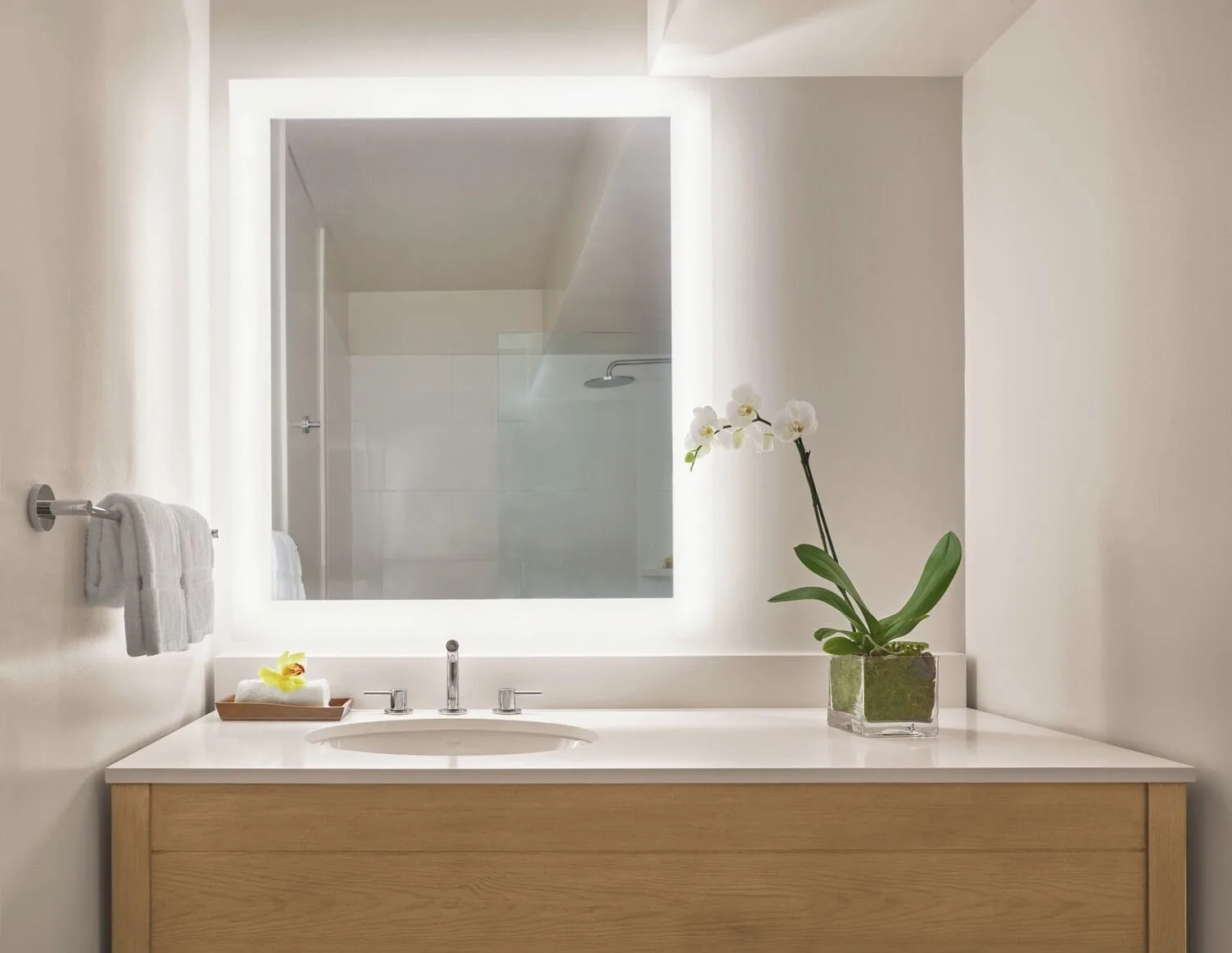Ocean View room bathroom vanity with lit mirror at 'Alohilani Resort Waikiki Beach.
