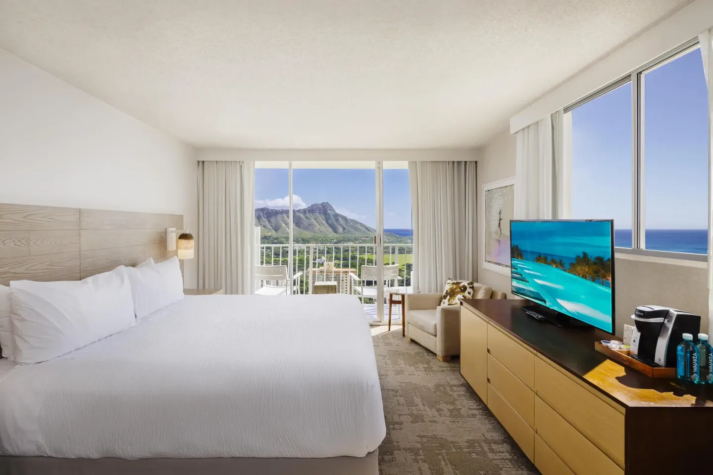 Waikiki Mountain View king guest room with balcony and Diamond Head view at 'Alohilani Resort Waikiki Beach.