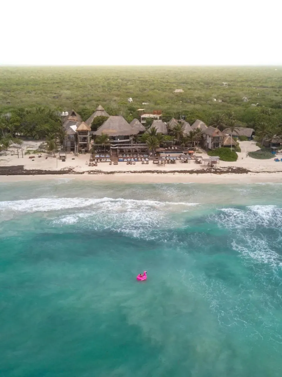 Aerial view of Amansala resort buildings and beach with turquoise sea in front
