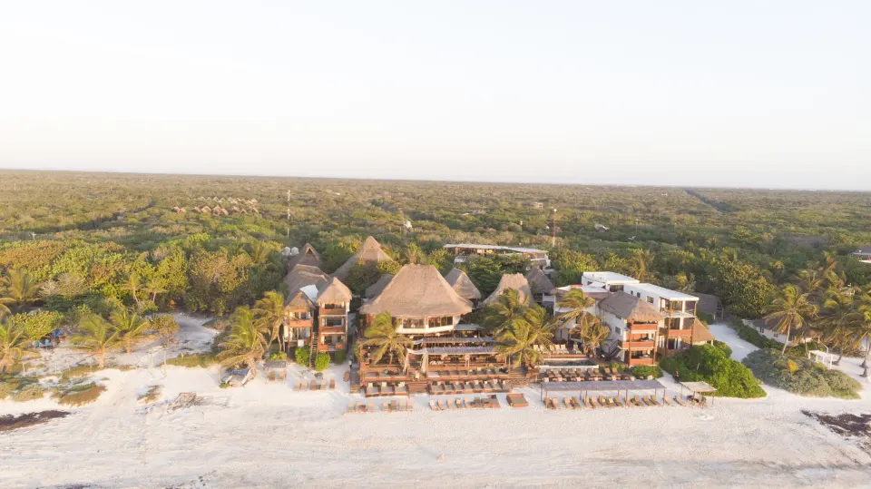 Aerial view of the Amansala resort complex and beachfront at sunrise or sunset