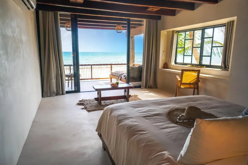 Guest room with exposed beams, king bed and balcony at Amansala