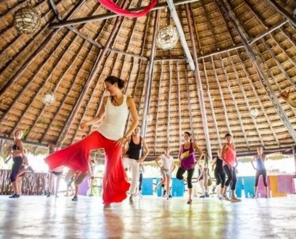 Dance or movement class under a thatched palapa at Amansala