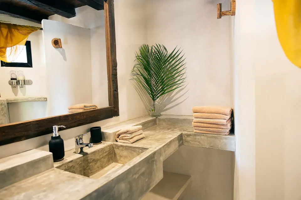 Long concrete bathroom counter with twin basins and folded towels at Amansala
