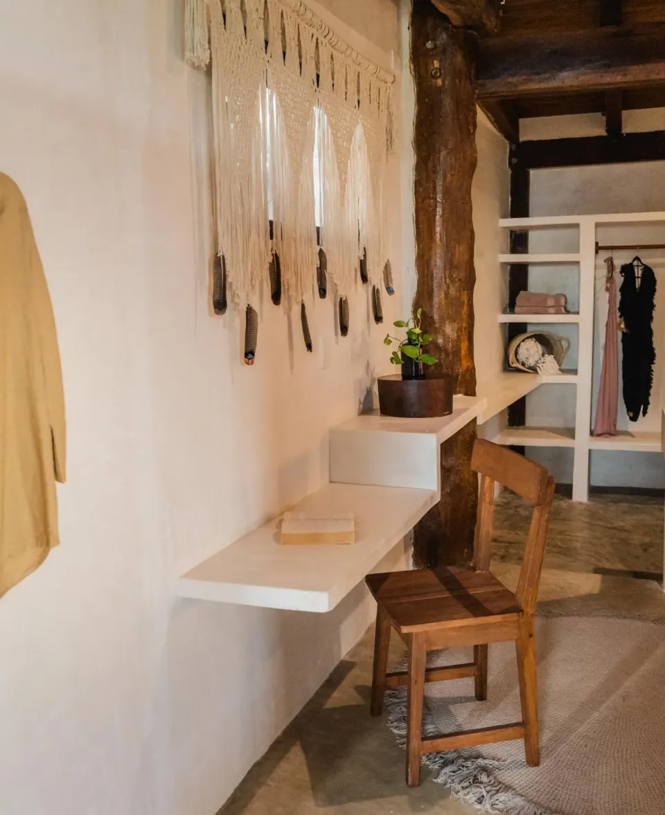 Small dressing nook with desk, chair and macramé wall hanging at Amansala
