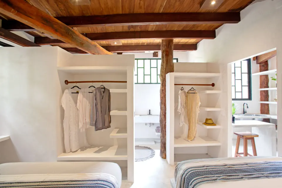 Open-plan bedroom with built-in shelving and two beds at Amansala