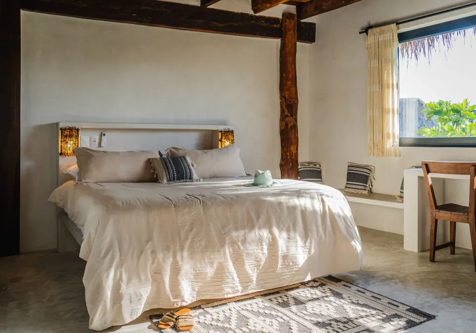 Bright bedroom with white linens and wooden accents at Amansala