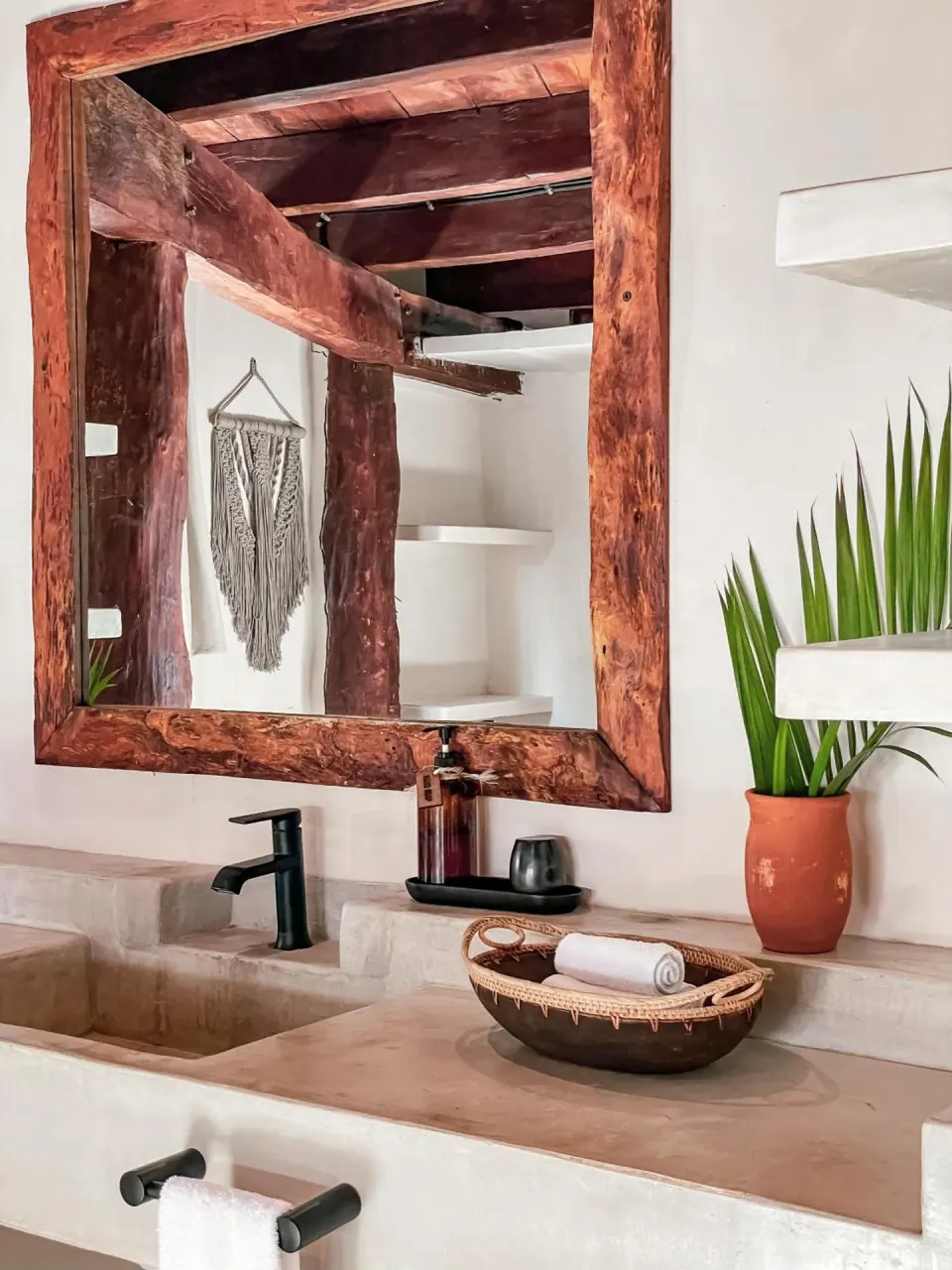 Bathroom sink and rustic wooden mirror in a guest room at Amansala