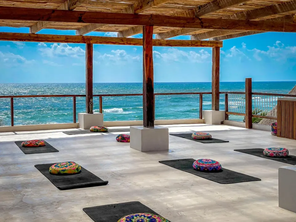Open-air yoga platform with mats facing the ocean at Amansala