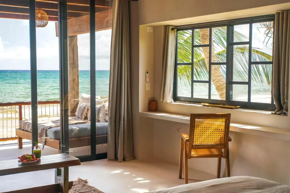 Seaside guest room with sliding doors opening to a balcony and ocean view at Amansala