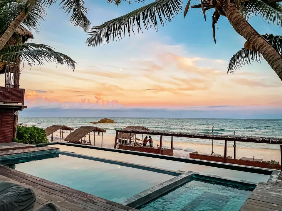 Resort pool with infinity edge and beach view at sunset at Amansala
