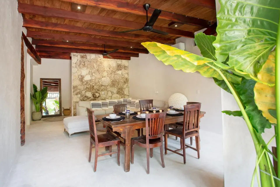 Indoor dining table and seating under wooden beams at Amansala