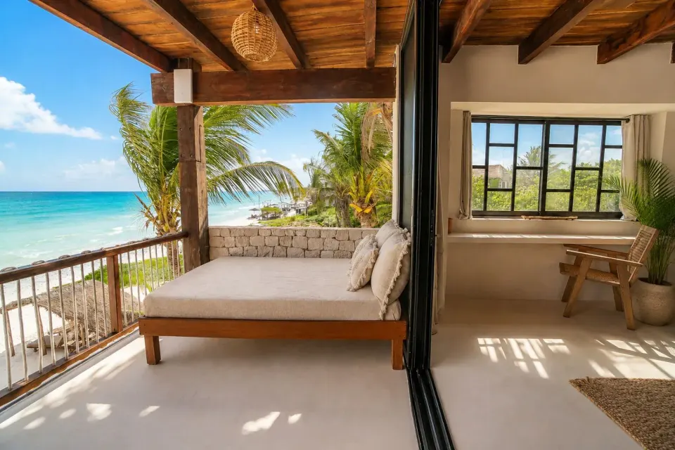 Open-air daybed on balcony looking down the beach at Amansala