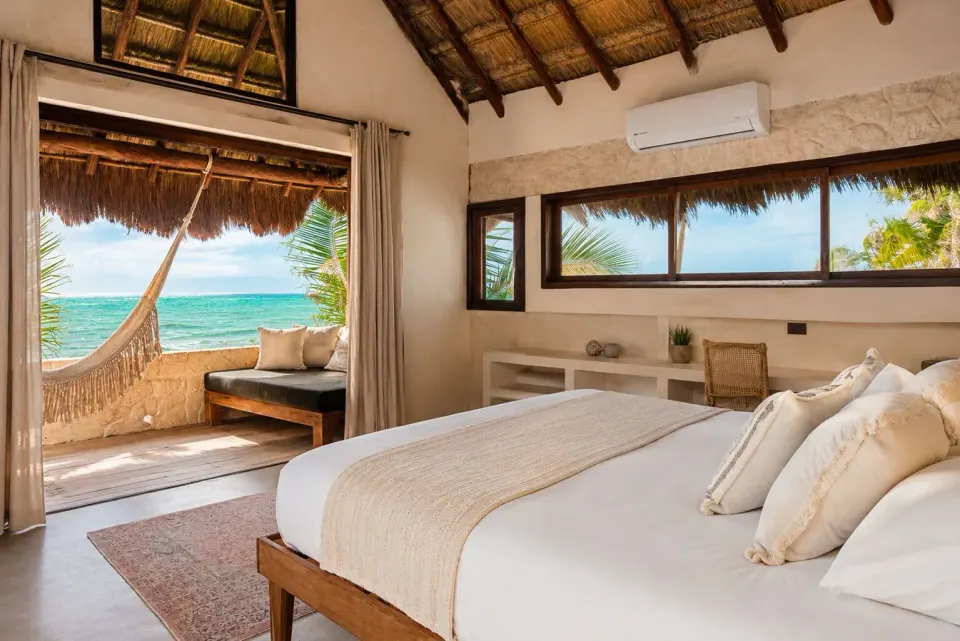 Beachfront bedroom with king bed, hammock and sea view at Amansala