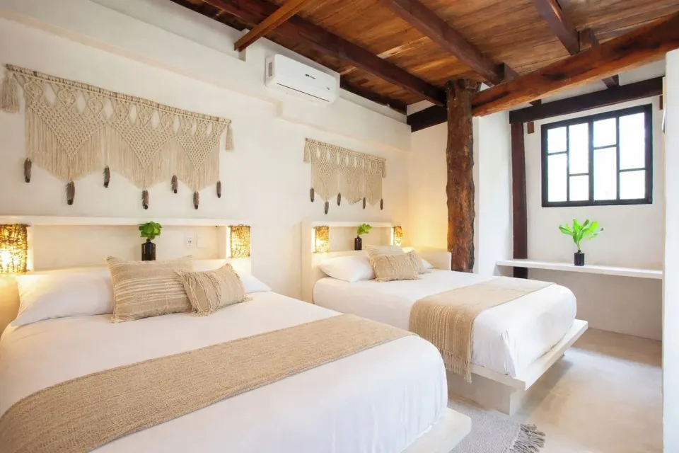 Two beds with macramé wall hangings in Town House Shanti at Amansala