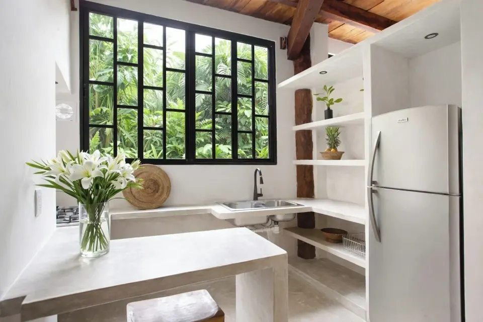 Compact kitchenette with large black-framed window in Town House Shanti at Amansala