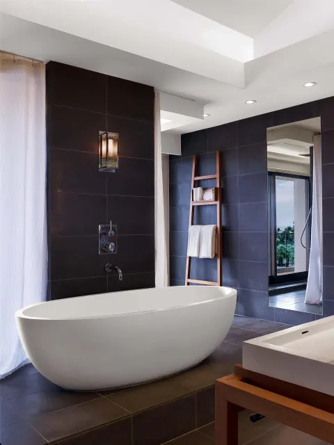 Bathroom with freestanding tub and dark tile walls at Andaz Maui at Wailea Resort.
