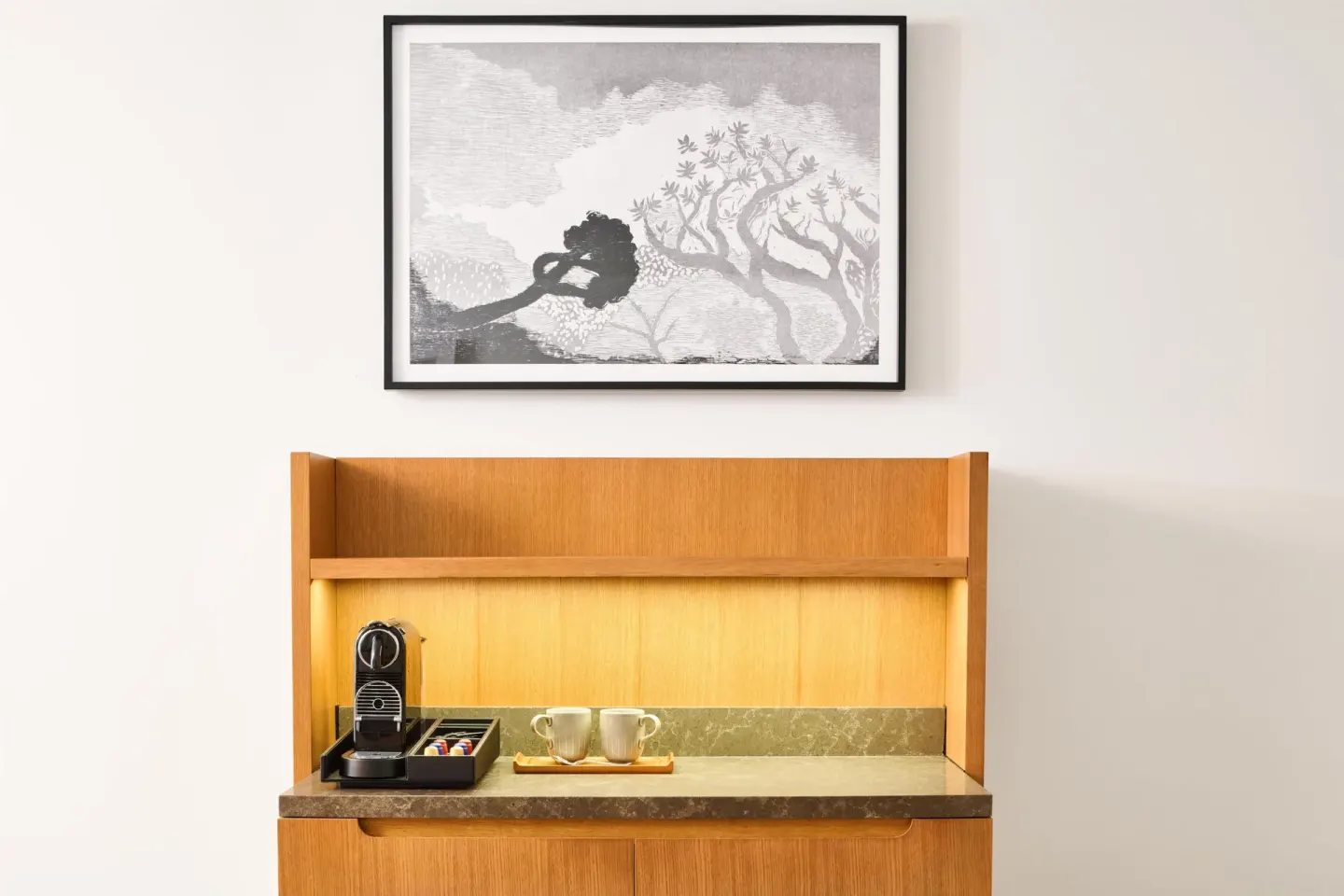 In-room coffee station with cups and wall art at Andaz Maui at Wailea Resort.