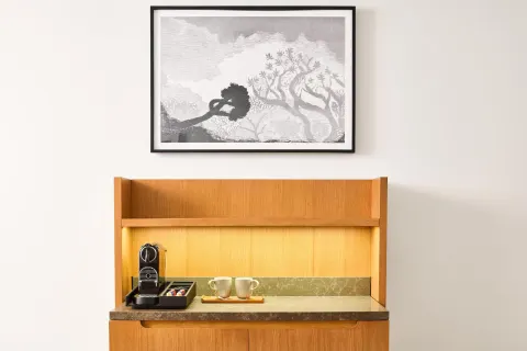 In-room coffee station with cups and wall art at Andaz Maui at Wailea Resort.