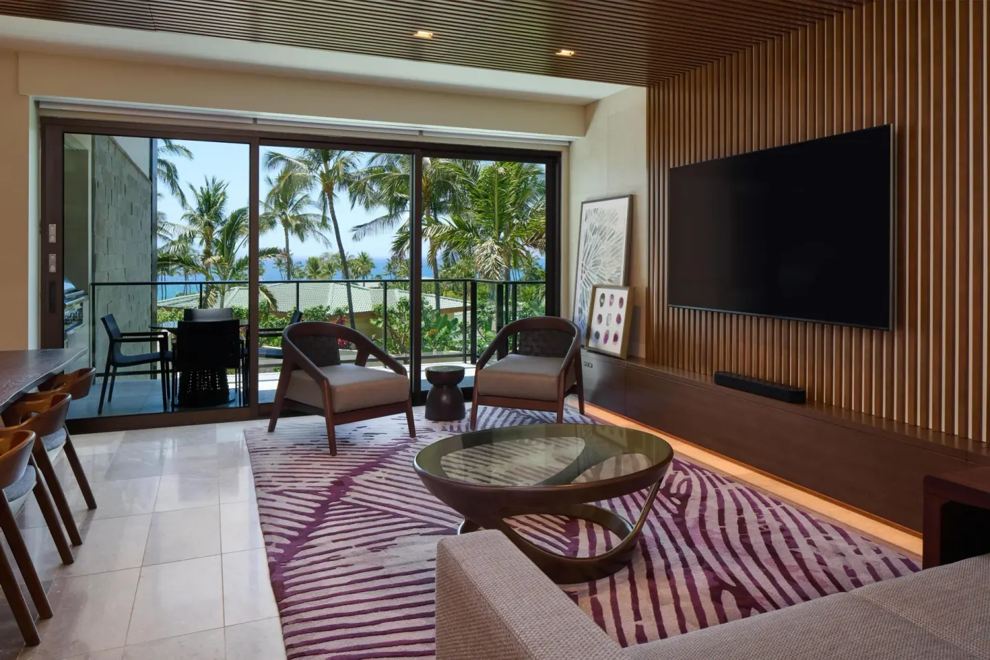 Living room with balcony, palms, and ocean glimpse at Andaz Maui at Wailea Resort.