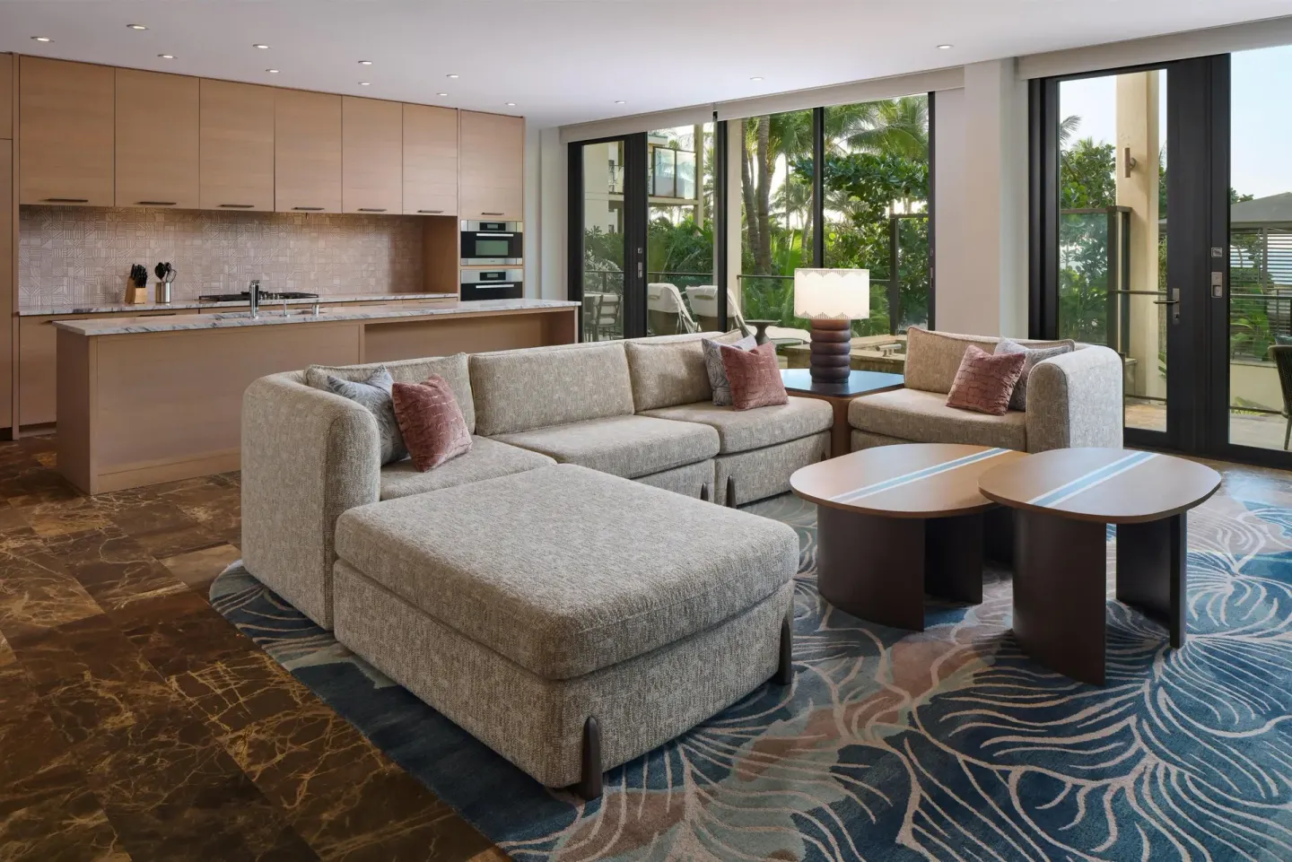 Suite living area with sectional sofa and kitchen at Andaz Maui at Wailea Resort.