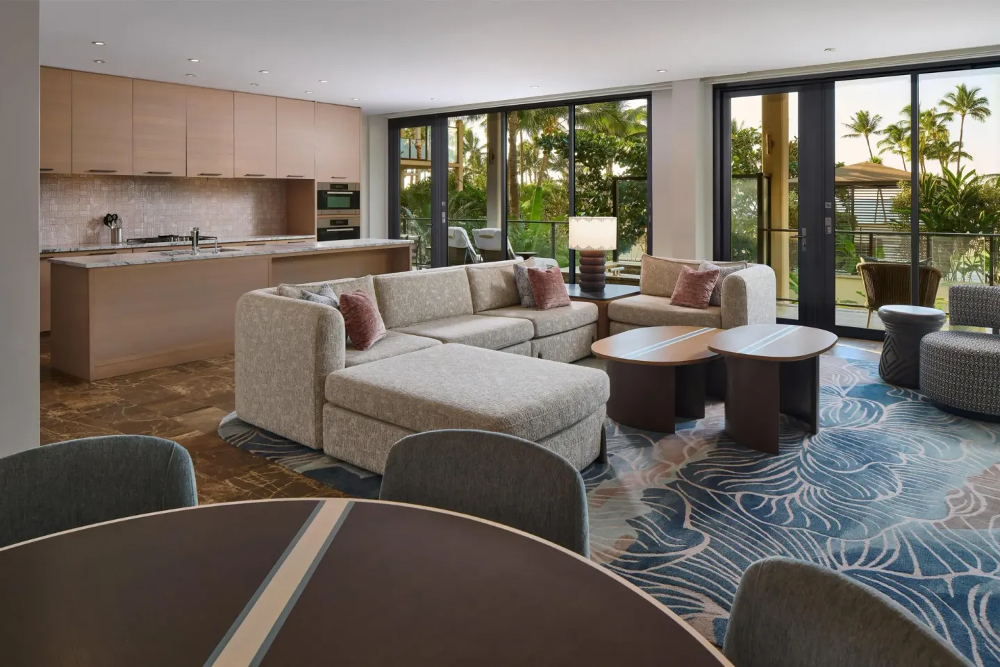 Open suite living room and kitchen with balcony doors at Andaz Maui at Wailea Resort.