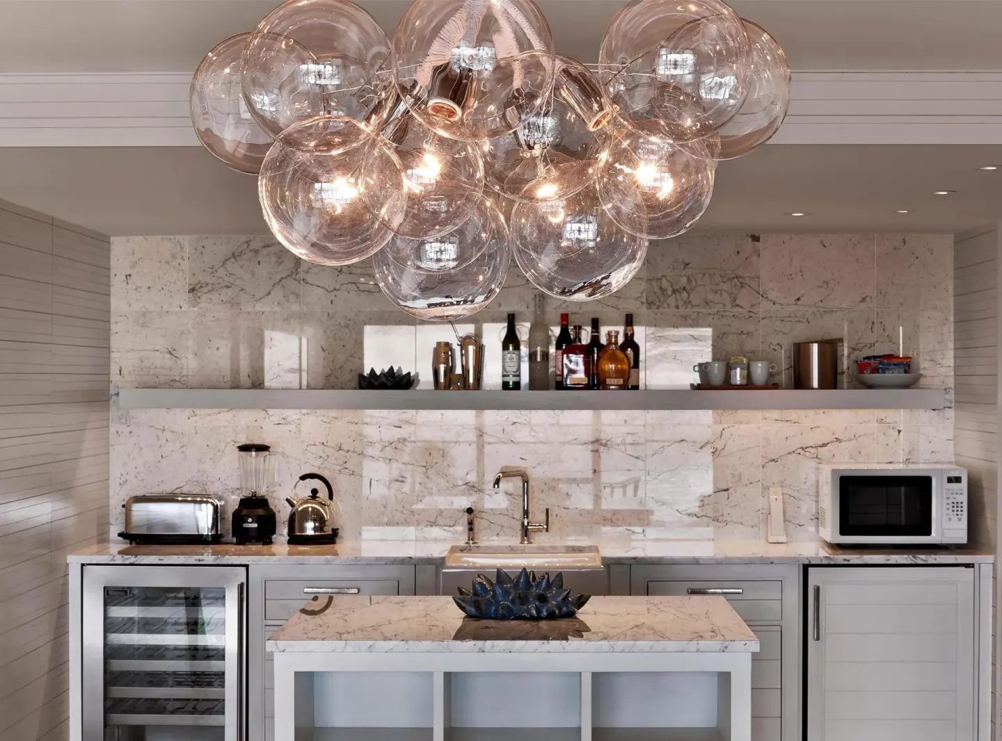 In-suite wet bar with marble surfaces and glass globe lighting at Andaz Maui at Wailea Resort.