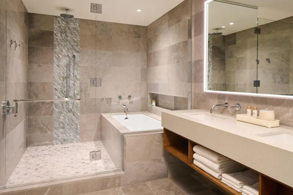 Bathroom with tub and glass shower in the 3 Bedroom Ilikai Villa at Andaz Maui at Wailea Resort.