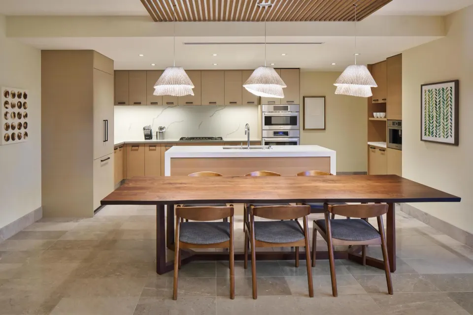 Dining table and kitchen in the 3 Bedroom Ilikai Villa at Andaz Maui at Wailea Resort.
