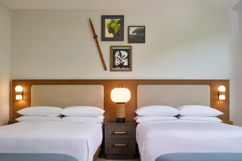 Villa bedroom with two beds, bedside lamps, and wall art at Andaz Maui at Wailea Resort.
