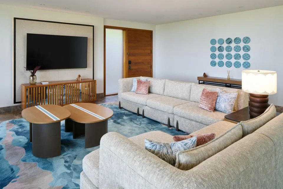 Oceanfront villa living room with sectional sofa and wall-mounted TV at Andaz Maui at Wailea Resort.