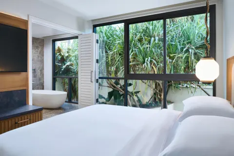 Oceanfront villa bedroom with king bed, garden windows, and bathtub at Andaz Maui at Wailea Resort.
