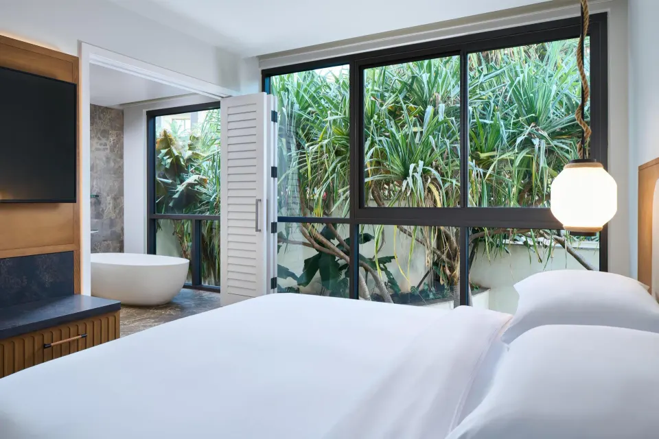 Oceanfront villa bedroom with king bed, garden windows, and bathtub at Andaz Maui at Wailea Resort.