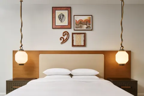 Bedroom with a king bed and framed wall art in an oceanfront villa at Andaz Maui at Wailea Resort.