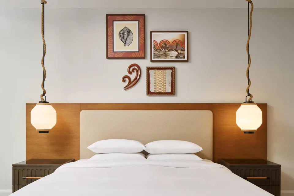 Bedroom with a king bed and framed wall art in an oceanfront villa at Andaz Maui at Wailea Resort.