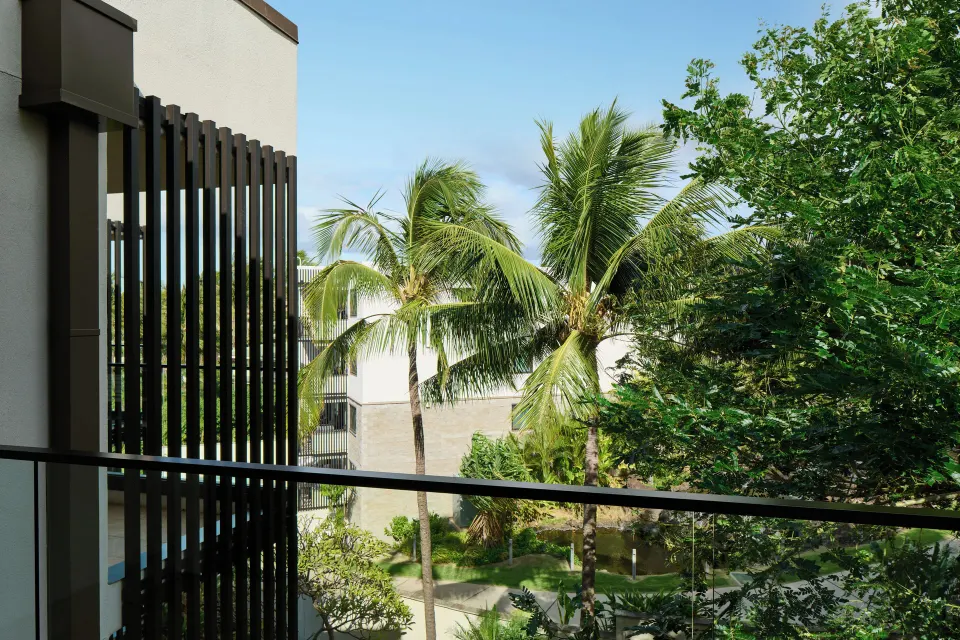 Resort view room balcony with palms and hotel buildings at Andaz Maui at Wailea Resort.