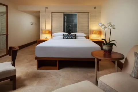 Resort View king room with bedside lamps and lounge seating at Andaz Maui at Wailea Resort.