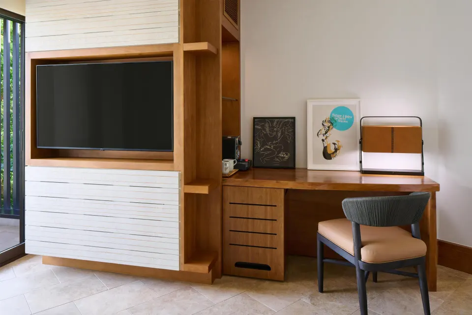 Guest room desk and TV wall with balcony beside it at Andaz Maui at Wailea Resort.